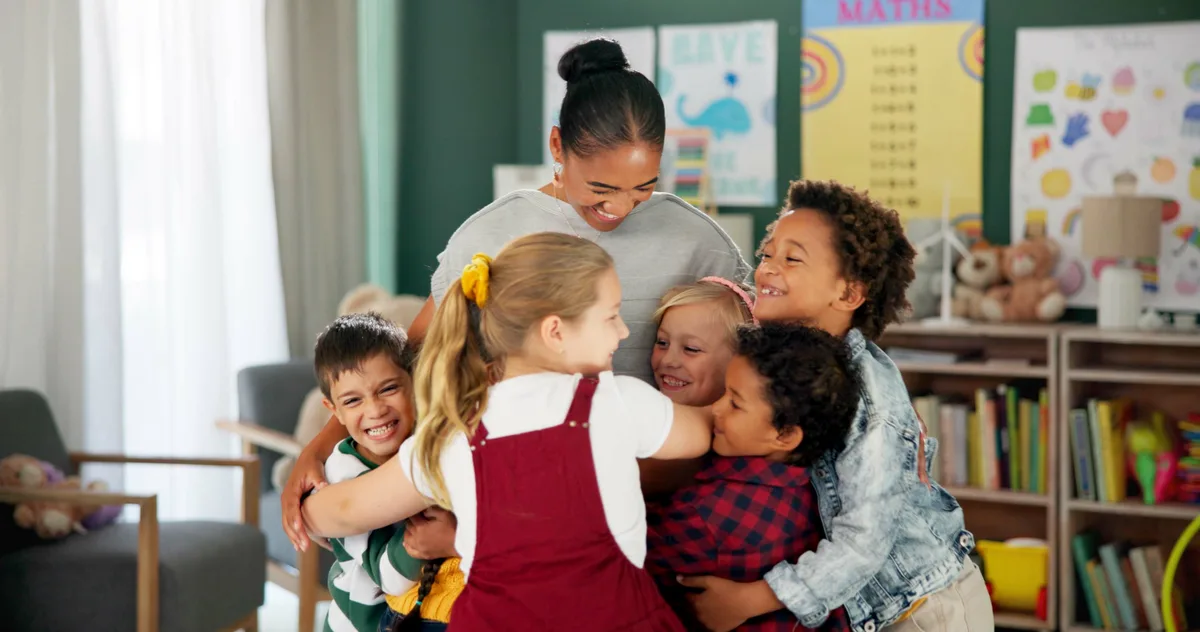 A teacher hugged by a group of children