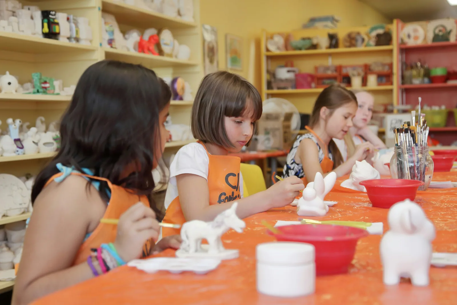 A bright art studio with children painting